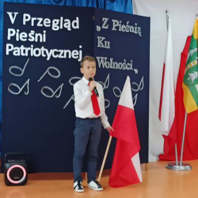 Uczeń szkoły biorący udział w przeglądzie pieśni patriotycznej.